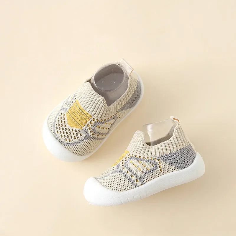 תינוק נועל גרבי נעל AirStep וזוחל בבטחה על רצפת פרקט.